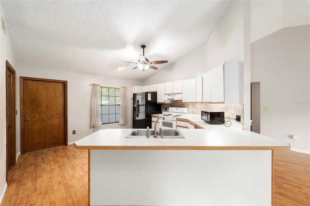 kitchen with white cabinets, kitchen peninsula, black appliances, sink, and light wood-type flooring