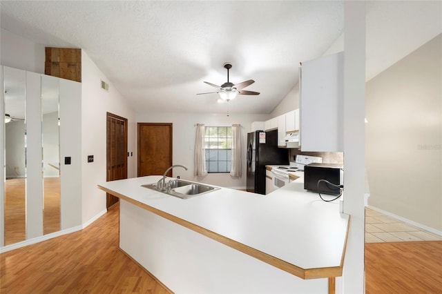 kitchen featuring vaulted ceiling, light hardwood / wood-style flooring, sink, white cabinetry, and white electric range