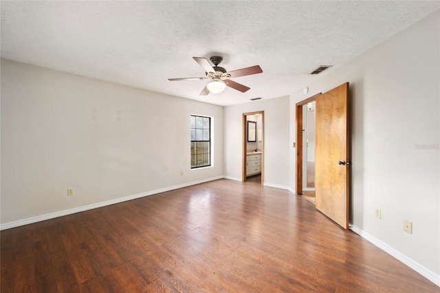 spare room with ceiling fan, a textured ceiling, and dark hardwood / wood-style flooring