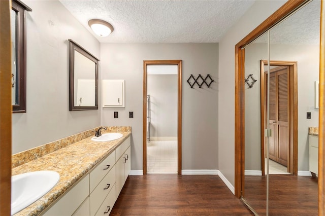 bathroom featuring vanity, hardwood / wood-style floors, and a textured ceiling