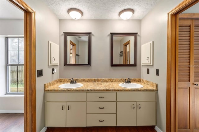 bathroom featuring hardwood / wood-style flooring, vanity, and a textured ceiling