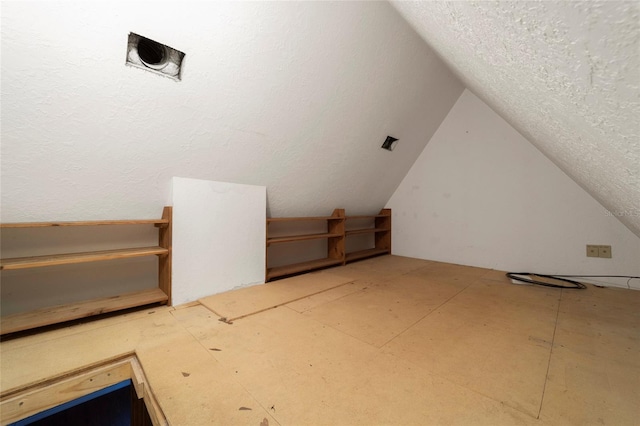 bonus room with a textured ceiling and lofted ceiling