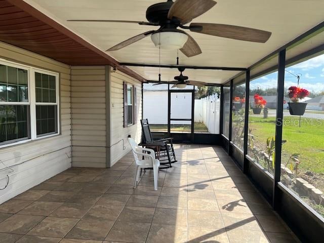 unfurnished sunroom featuring ceiling fan