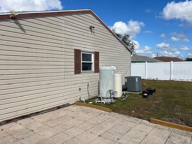 view of home's exterior with cooling unit, a patio, and a yard