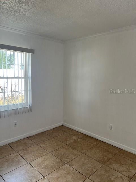 unfurnished room featuring ornamental molding, a textured ceiling, and light tile patterned floors