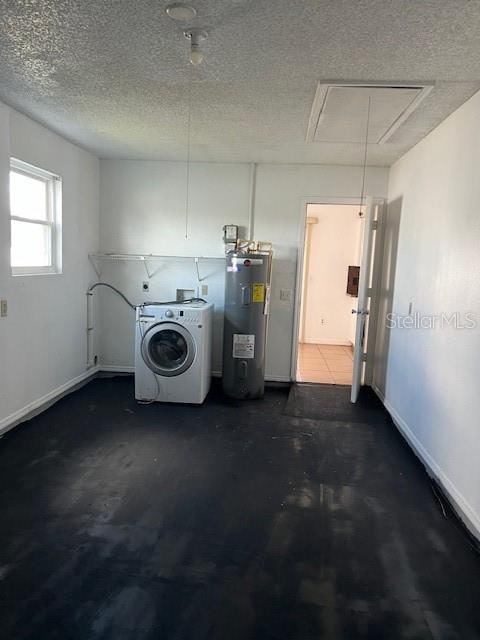 clothes washing area featuring electric water heater, washer / dryer, and a textured ceiling