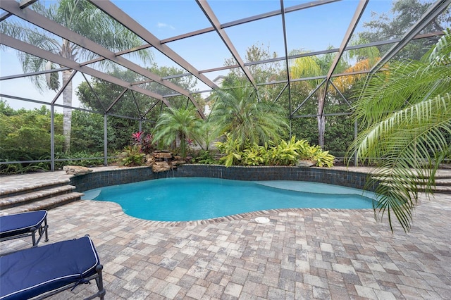 view of swimming pool with a patio area and a lanai