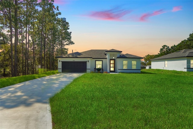 view of front of property featuring a garage and a yard