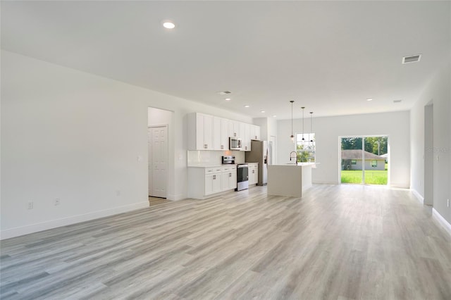 unfurnished living room with light hardwood / wood-style floors and sink