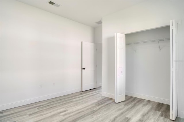 unfurnished bedroom featuring a closet and light wood-type flooring