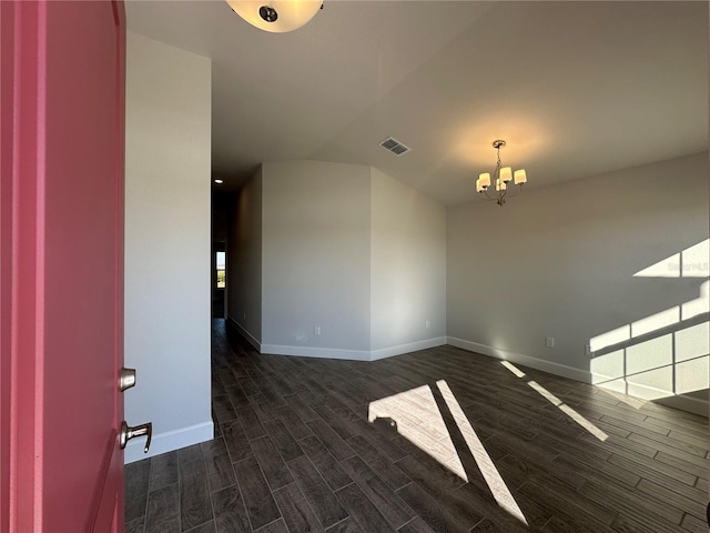 unfurnished room with dark hardwood / wood-style floors and an inviting chandelier