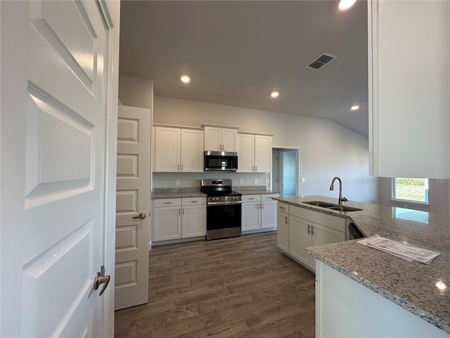 4489 SW 90th Pl, Ocala, FL 34476 - kitchen with stainless steel appliances, a sink, white cabinets, light stone countertops, and recessed lighting