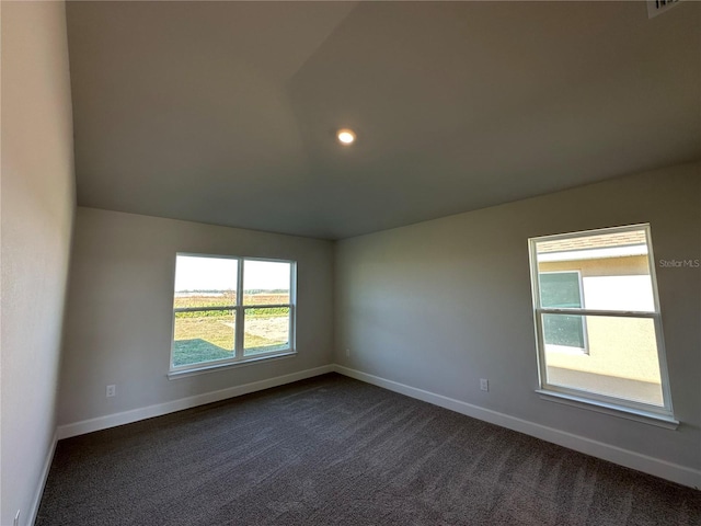 unfurnished room with dark carpet