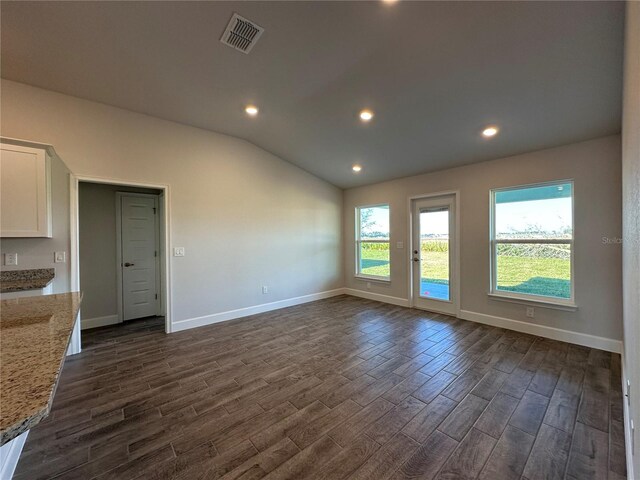 4489 SW 90th Pl, Ocala, FL 34476 - unfurnished living room featuring dark wood-style flooring, lofted ceiling, baseboards, and recessed lighting