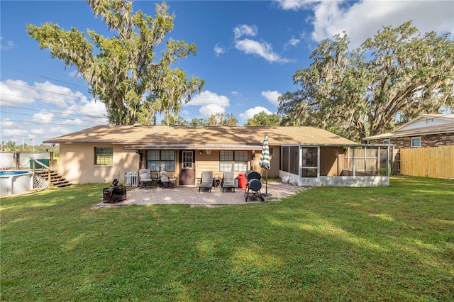 back of property featuring a lawn, a sunroom, and a patio area