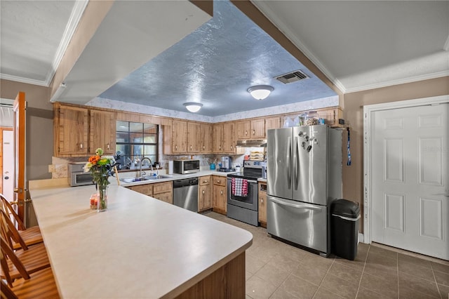 kitchen with ornamental molding, stainless steel appliances, sink, and light tile patterned floors