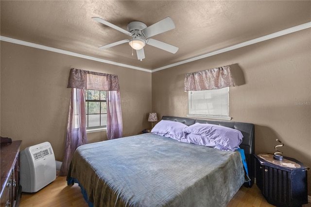 bedroom with ceiling fan, light hardwood / wood-style flooring, and crown molding