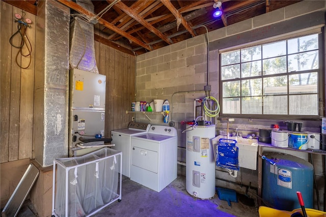 interior space with wood walls, electric water heater, and separate washer and dryer