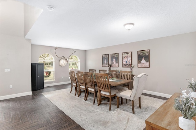 dining room with dark parquet floors and a chandelier