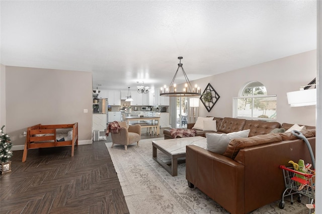 living room with an inviting chandelier and parquet flooring