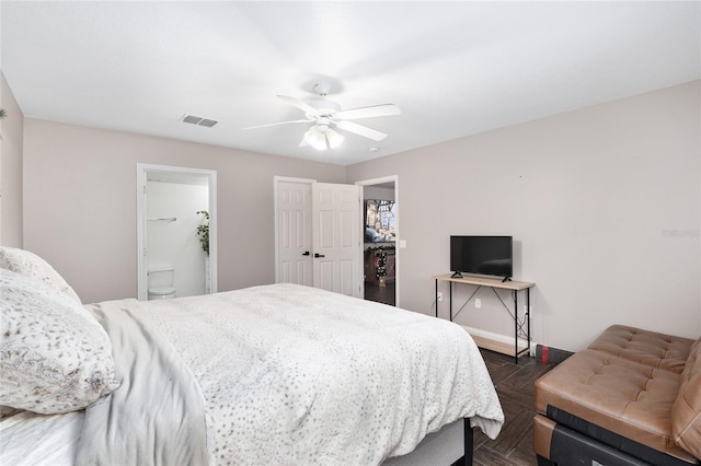 bedroom featuring dark parquet flooring, ceiling fan, and connected bathroom