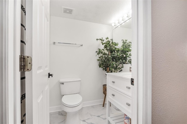 bathroom with toilet, vanity, and a textured ceiling