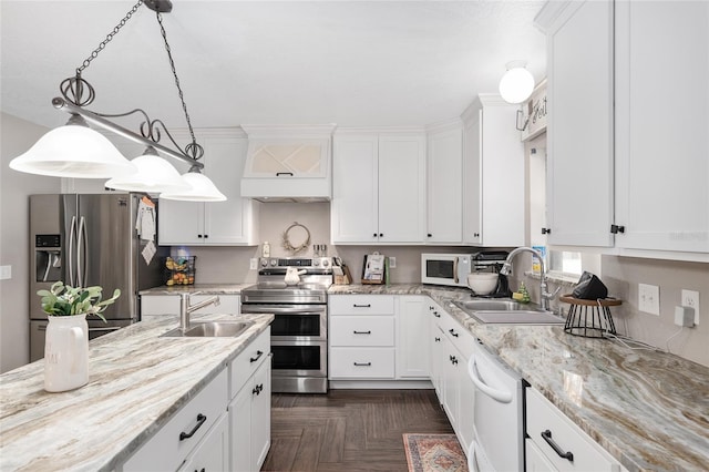 kitchen with decorative light fixtures, appliances with stainless steel finishes, sink, and white cabinets