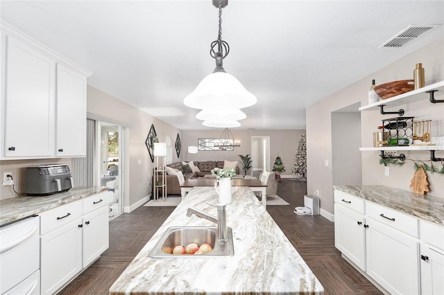 kitchen featuring white cabinetry, light stone counters, pendant lighting, and a kitchen island