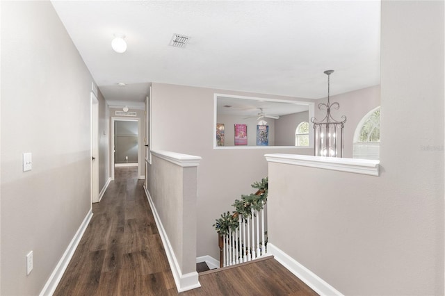 hall featuring dark hardwood / wood-style floors and an inviting chandelier