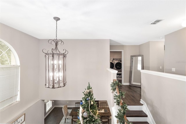 dining room with dark hardwood / wood-style flooring, a notable chandelier, and washer and dryer