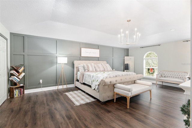 bedroom with lofted ceiling, dark hardwood / wood-style flooring, and a notable chandelier