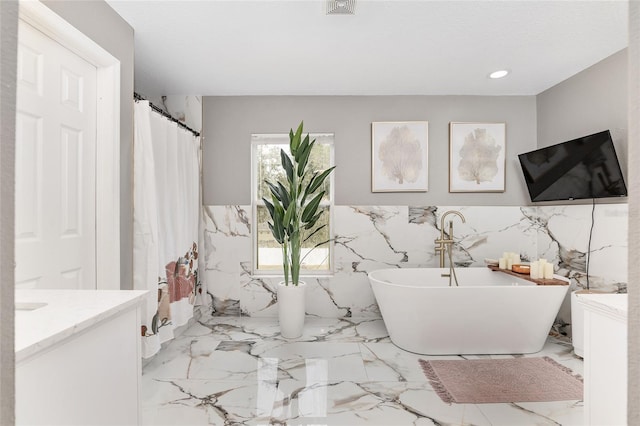 bathroom with vanity, tile walls, and shower with separate bathtub