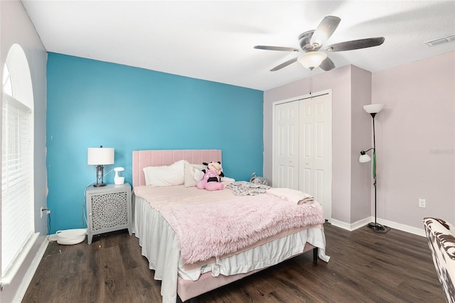 bedroom featuring dark wood-type flooring, ceiling fan, and a closet