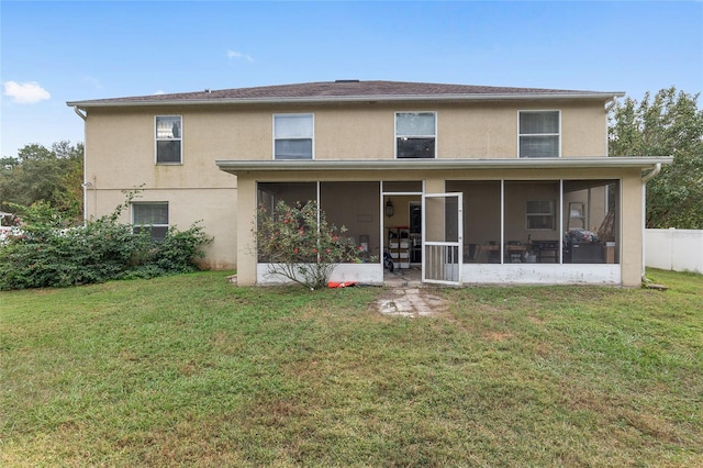 rear view of property with a lawn and a sunroom