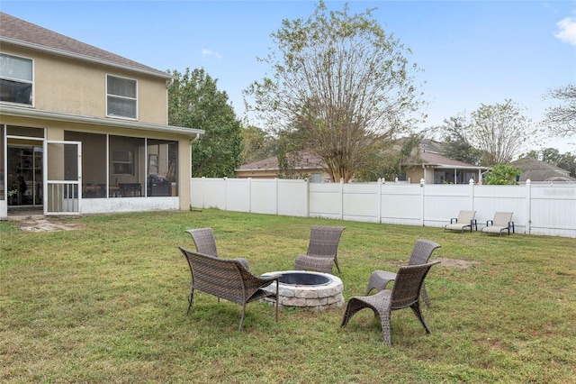 view of yard featuring a sunroom and a fire pit