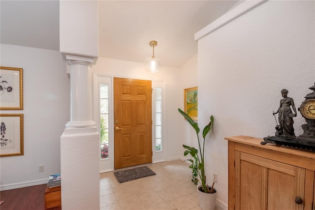 tiled foyer entrance with ornate columns and vaulted ceiling