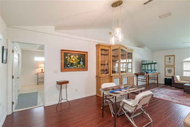 dining space with lofted ceiling and dark wood-type flooring