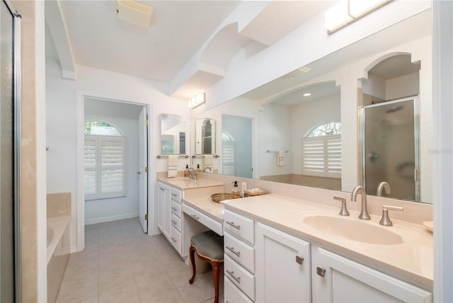 bathroom with tile patterned floors, vanity, independent shower and bath, and a wealth of natural light