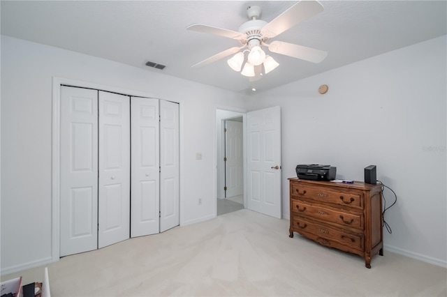 carpeted bedroom featuring a closet and ceiling fan