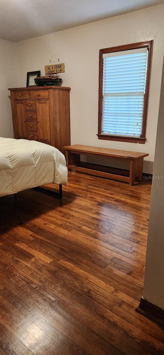 bedroom with dark hardwood / wood-style flooring