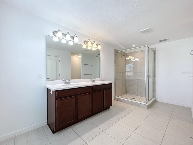 bathroom featuring tile patterned floors, vanity, an enclosed shower, and a textured ceiling