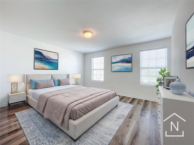 bedroom featuring hardwood / wood-style floors and a textured ceiling