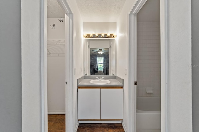 full bathroom with vanity, wood finished floors, bathtub / shower combination, and a textured ceiling