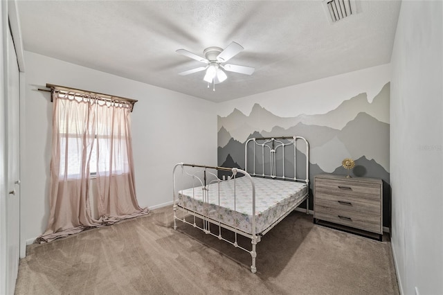 carpeted bedroom featuring visible vents, a textured ceiling, and ceiling fan