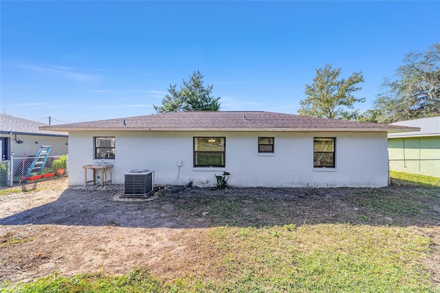 back of house featuring central air condition unit, fence, and stucco siding