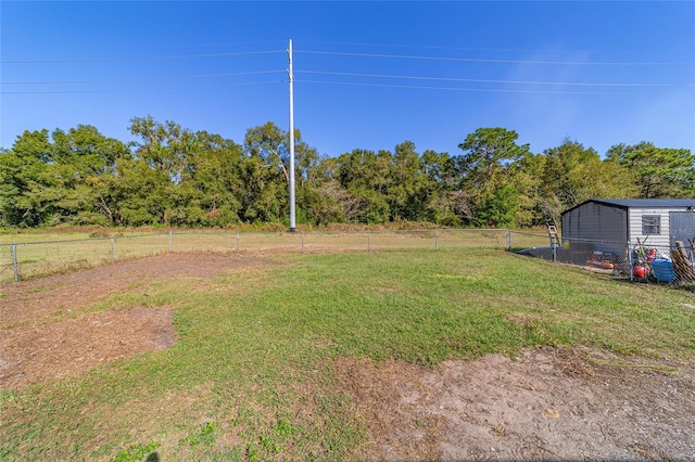 view of yard featuring an outbuilding and fence