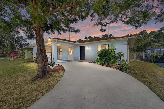 single story home featuring a front yard, fence, and stucco siding