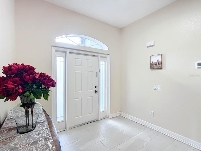 foyer entrance with a wealth of natural light and light tile patterned floors