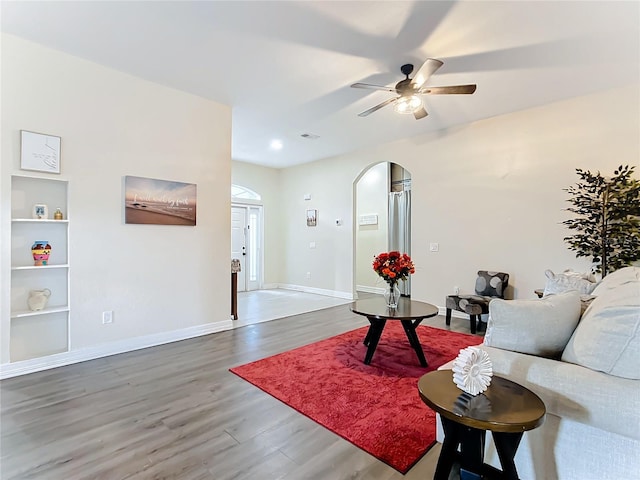 227 Locust Pass Crse, Ocala, FL 34472 - living area with arched walkways, wood finished floors, baseboards, ceiling fan, and built in shelves