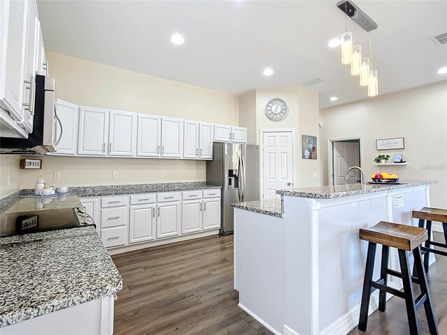 227 Locust Pass Crse, Ocala, FL 34472 - kitchen featuring stainless steel appliances, white cabinetry, dark wood-style floors, a kitchen breakfast bar, and decorative light fixtures
